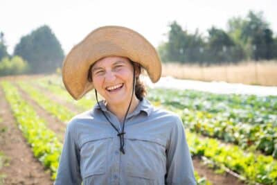 Melissa, the owner of Sun Love Farm, smiling in her farm fields